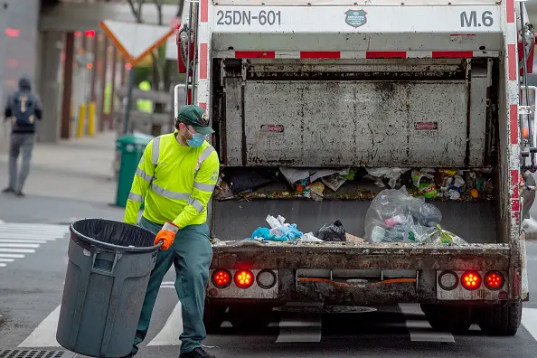 A sanitation worker in New York City removes the trash.